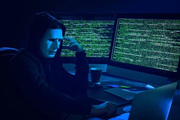 Hacker em máscara usando o computador — Fotografia de Stock