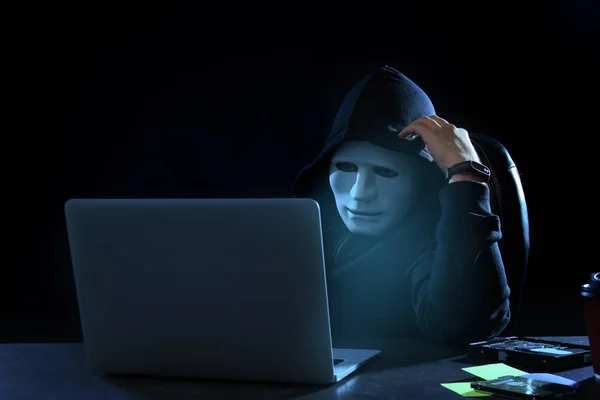 Hacker em máscara usando laptop — Fotografia de Stock