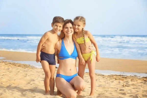 Söta lilla barn med mamma på stranden på resort — Stockfoto