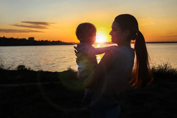 Giovane madre che tiene il bambino, all'aperto — Foto Stock