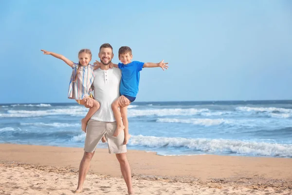 Cute little children with father on sea beach at resort — Stock Photo, Image