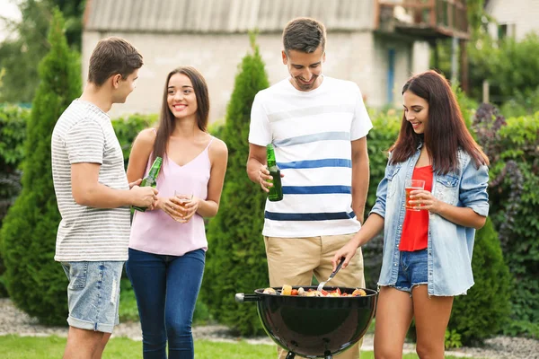 Unge venner har grill fest i haven - Stock-foto