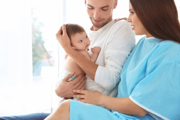 Feliz familia joven con lindo bebé en el hospital — Foto de Stock