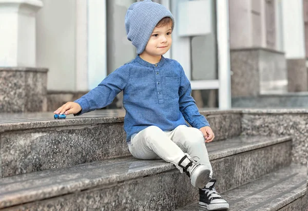 Adorable petit garçon assis sur les escaliers à l'extérieur — Photo