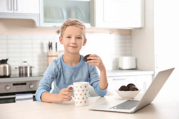 Ładny chłopczyk z laptopa w kuchni — Zdjęcie stockowe