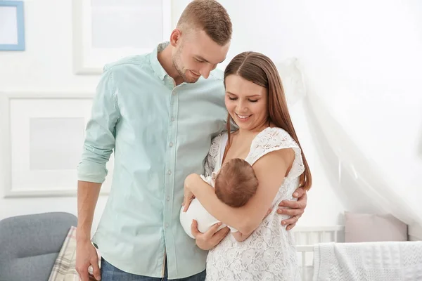 Feliz familia joven con lindo bebé en casa — Foto de Stock