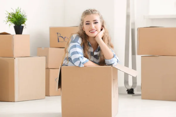 Jovem mulher em caixa em movimento na nova casa — Fotografia de Stock