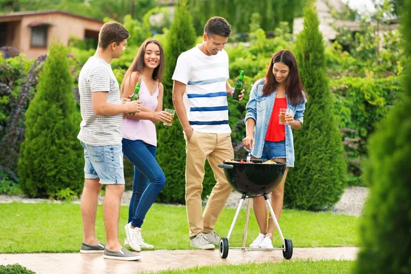 Giovani amici che fanno festa barbecue in giardino — Foto Stock