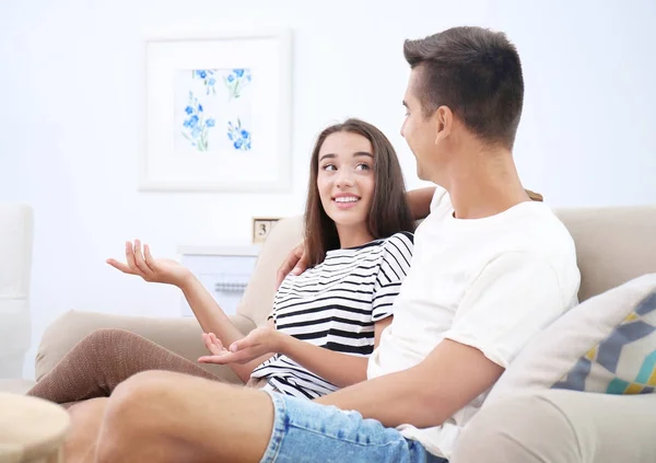 Jeune couple sur canapé à la maison — Photo