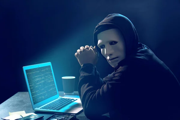 Hacker in maschera con computer portatile — Foto Stock