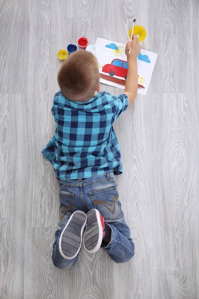 Lindo niño pintura imagen en hoja de papel, en el interior — Foto de Stock