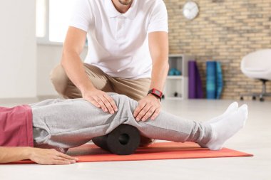 Fizyoterapist klinikte genç erkek hasta ile çalışma
