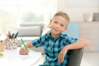 Evde çizim yapan şirin bir çocuk.