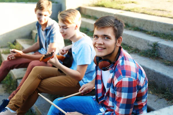 Músicos adolescentes sentados em degraus ao ar livre — Fotografia de Stock