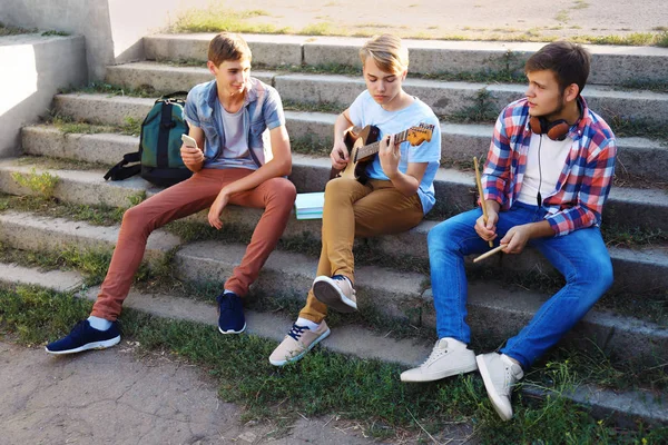 Teenager musicisti seduti su gradini all'aperto — Foto Stock