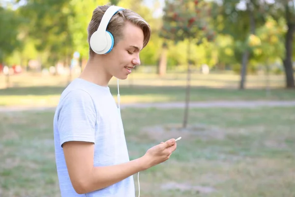 Adolescente chico con auriculares escuchando música al aire libre —  Fotos de Stock