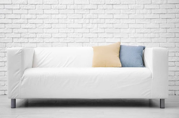 Удобный диван на фоне кирпичной стены — стоковое фото