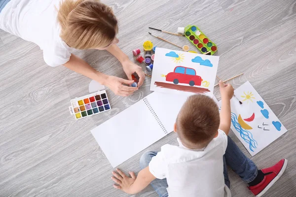 Mère avec mignon garçon peinture tableau sur feuille de papier, à l'intérieur — Photo