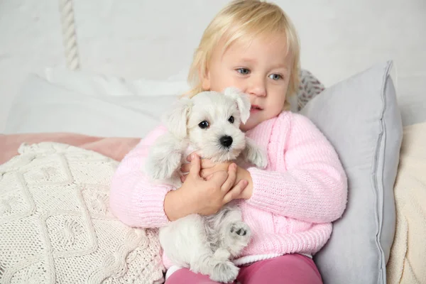 Menina bonito pouco com filhote de cachorro em casa — Fotografia de Stock