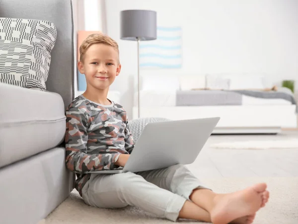Милый маленький мальчик с ноутбуком дома — стоковое фото