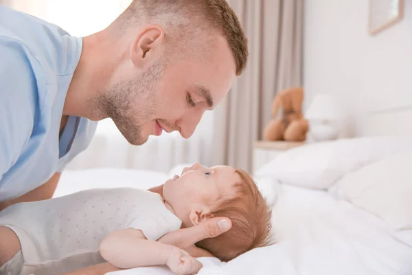 Joven padre con bebé en la cama en casa — Foto de Stock