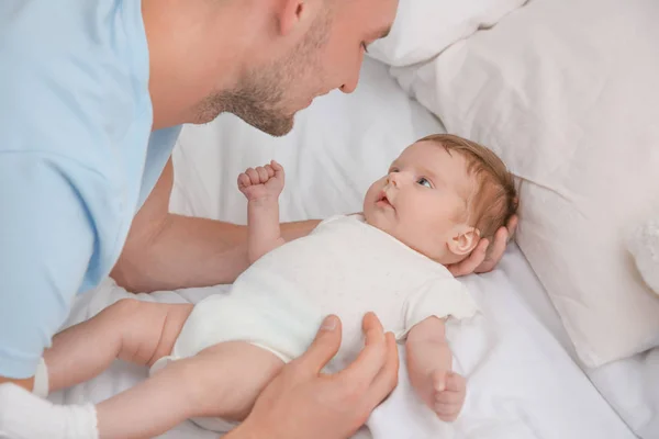 Ayah muda dengan bayi di tempat tidur di rumah — Stok Foto