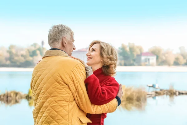 Älteres Ehepaar am Herbsttag in der Nähe des Flusses — Stockfoto