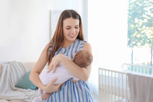 Jovem mãe segurando bebê em casa — Fotografia de Stock