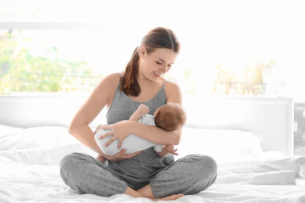 Ibu muda dengan bayi di tempat tidur di rumah — Stok Foto