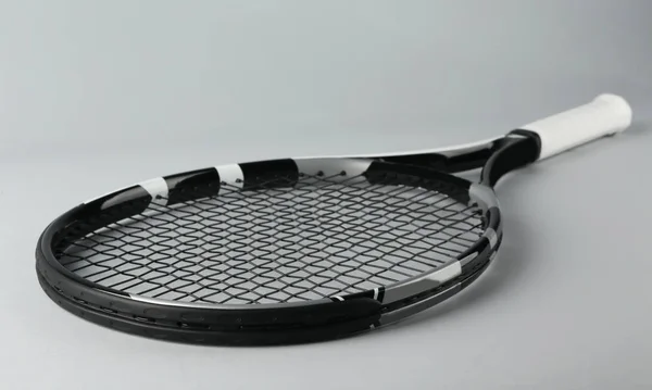 Raquete de tênis em fundo cinza — Fotografia de Stock