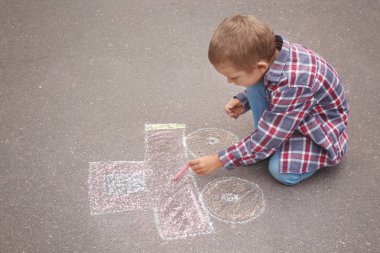 Küçük çocuk araba tebeşir ile asfalt üzerinde çizim
