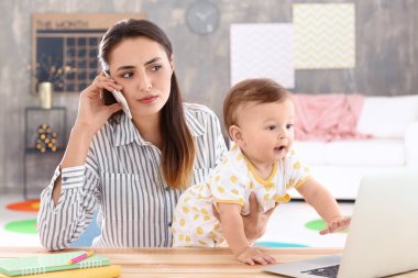 Ev ofisinde çalışırken holding bebek genç anne