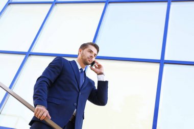 Cep telefonuyla konuşan yakışıklı iş adamı.