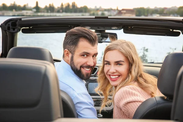 Szczęśliwa Młoda para w samochodzie, na brzegu rzeki — Zdjęcie stockowe