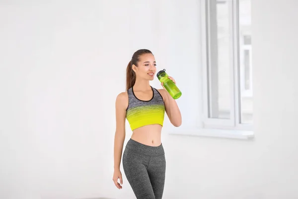 Mujer joven deportiva con botella — Foto de Stock