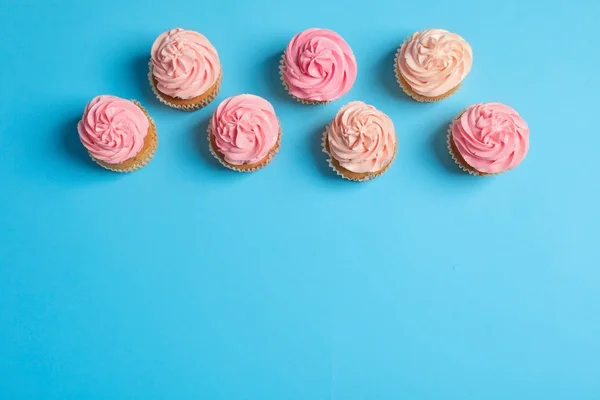 Много вкусных кексов на цветном фоне — стоковое фото