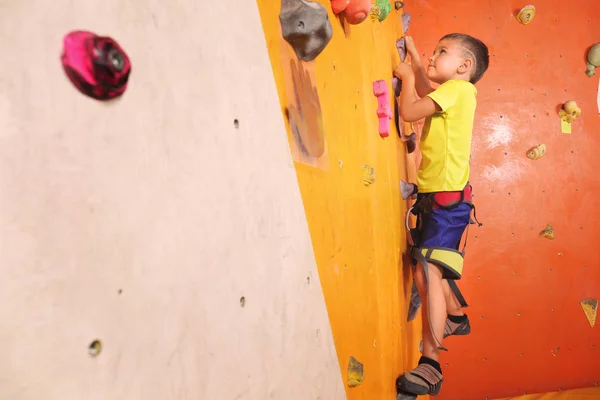 Adorable niño escalando en la pared en el gimnasio — Foto de Stock