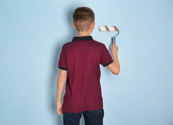 Cute little boy painting wall with roller — Stock Photo, Image
