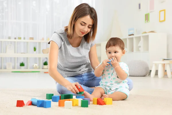 Mor med baby boy spelar hemma — Stockfoto
