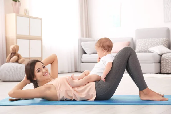 Jovem mãe fazendo ioga com bebê — Fotografia de Stock