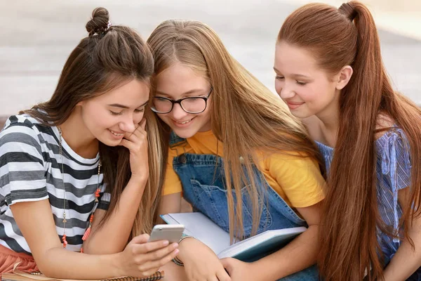 Милые подростки с мобильным телефоном на открытом воздухе — стоковое фото