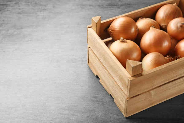 Cajón de madera con cebolla amarilla fresca cruda — Foto de Stock