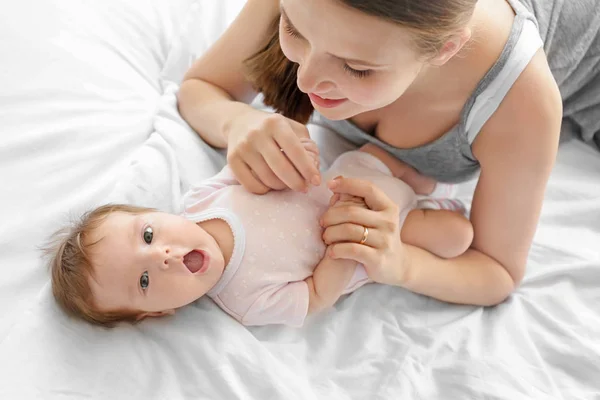 Ibu muda dengan bayi di tempat tidur — Stok Foto