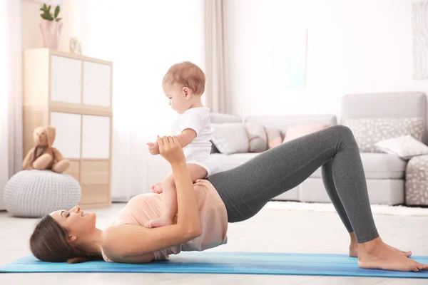 Jovem mãe fazendo ioga com bebê — Fotografia de Stock