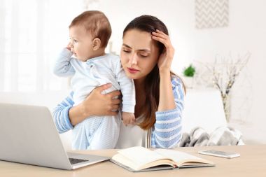 Ev ofisinde çalışırken holding bebek genç anne