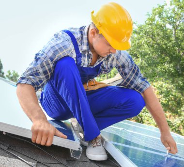 Dışarıda güneş panelleri kuran işçiler