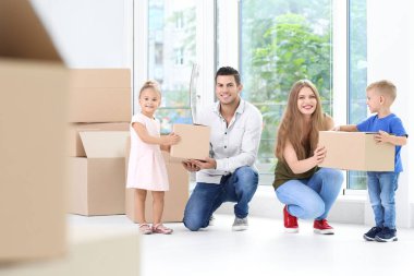 Yeni evlerinde kutuları taşıyan mutlu bir aile.