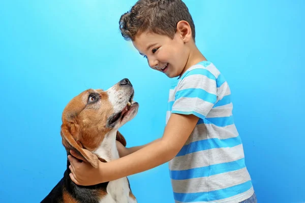 Schattige jongen met hond op kleur achtergrond — Stockfoto