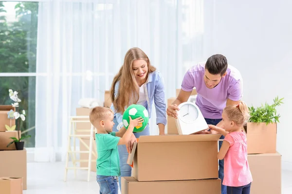 Familia feliz desempacando cajas móviles en su nueva casa — Foto de Stock