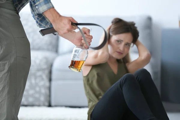 Muž s lahví alkoholu a pás zneužívání mladá žena — Stock fotografie